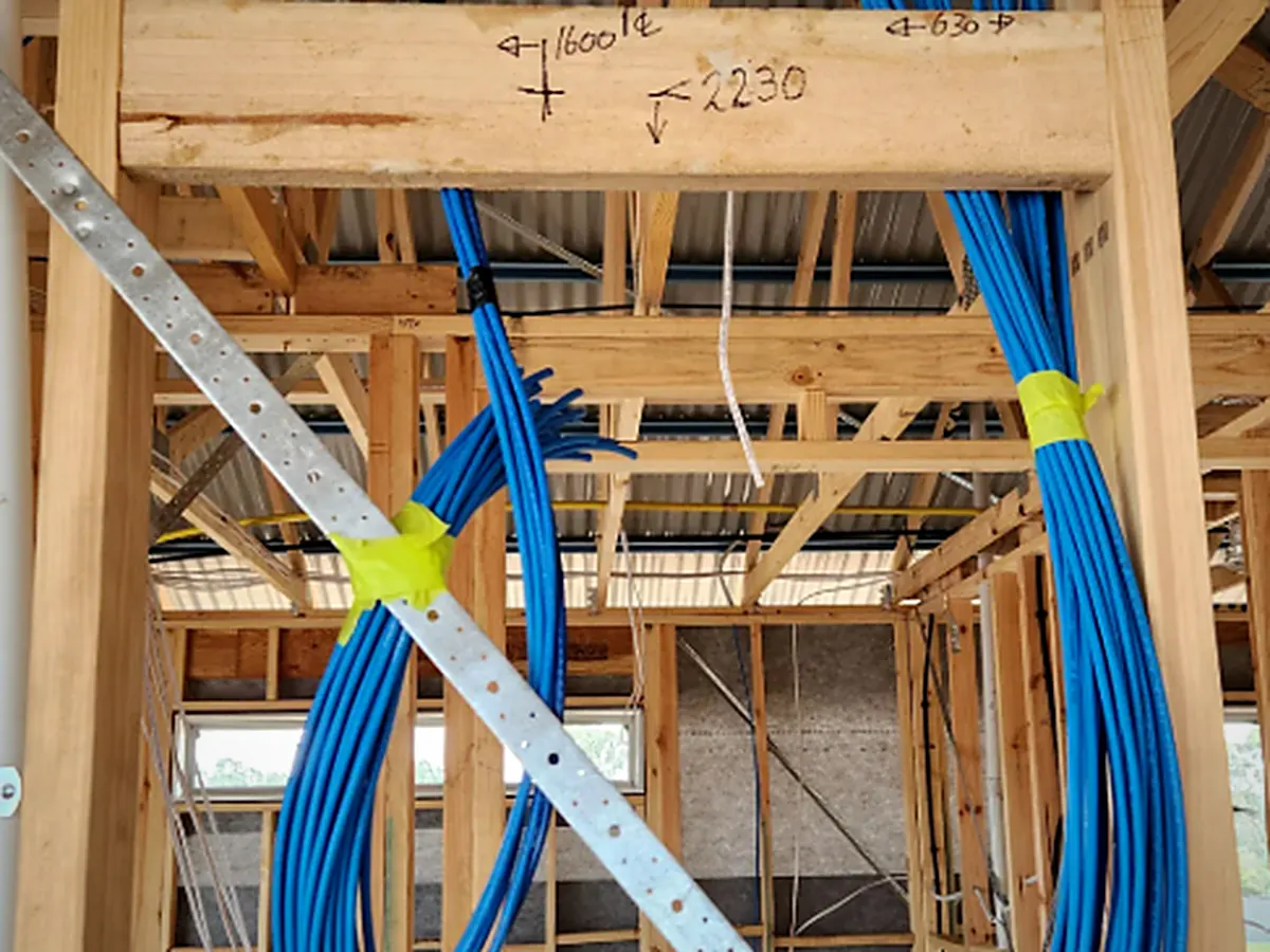 Coiled Cat6 service loops tied off in the framing, ready for termination