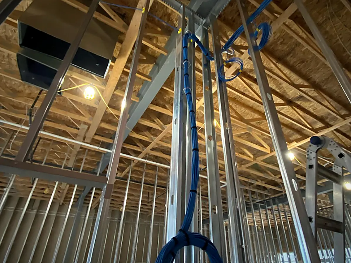 Cat6 low-voltage rough-in pulled through steel framing before drywall
