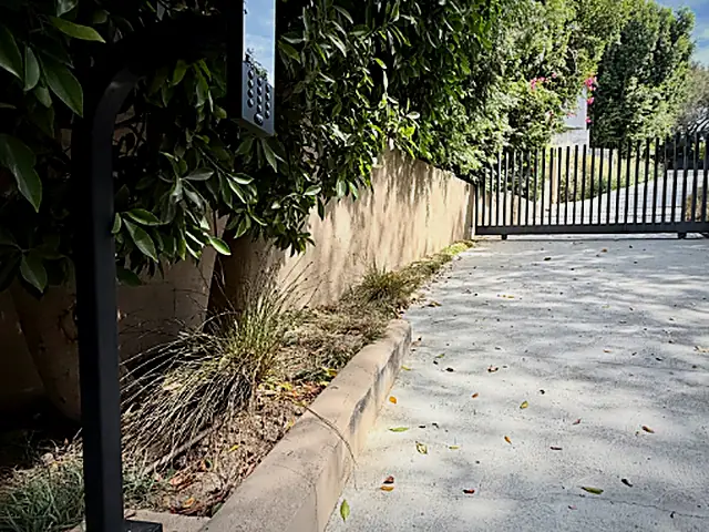 Intercom bollard at a gated driveway entrance